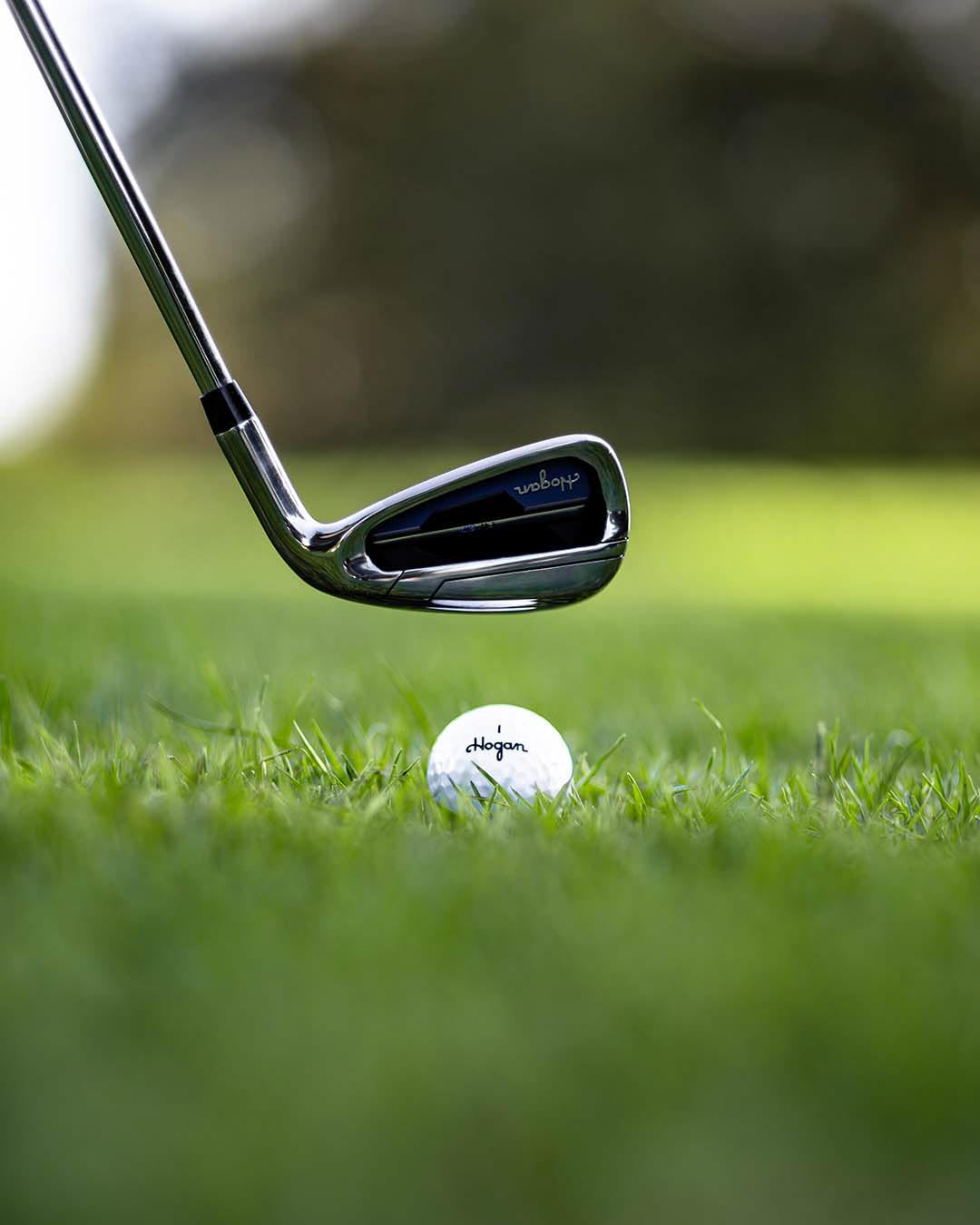 Chrome Ben Hogan iron at address above a golf ball, backlit at golden hour, by Niaz Uddin