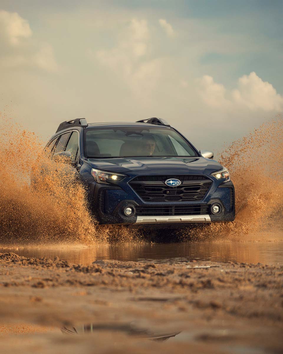 Subaru Outback splashing through mud off-road in action, by Niaz Uddin