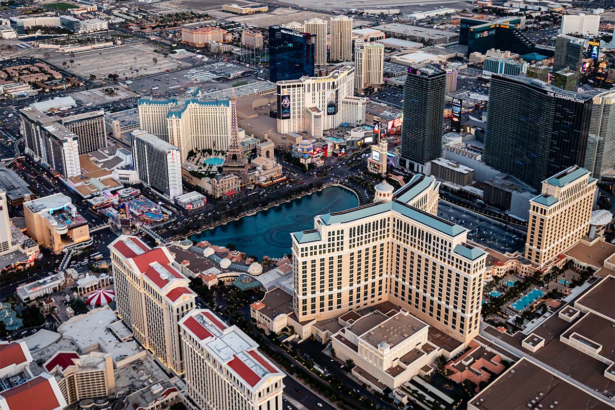 Daytime aerial of the Las Vegas Strip over the Bellagio and its fountain lake, with Caesars Palace, the Paris Las Vegas Eiffel Tower, and The Cosmopolitan, by Niaz Uddin