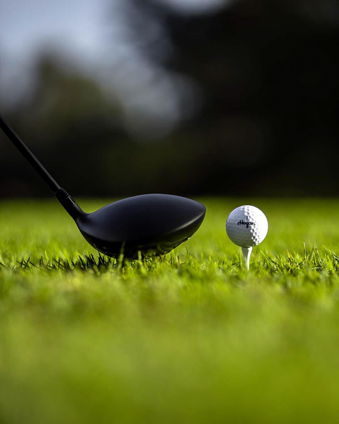 Black Ben Hogan driver behind a golf ball on a tee, low angle on the fairway, by Niaz Uddin