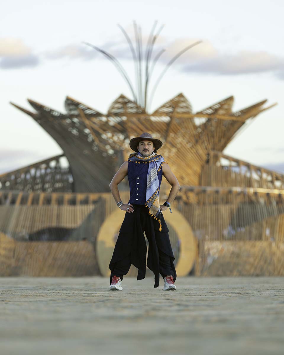 Phoenix Delgado standing in front of the 2026 Burning Man temple at golden hour, by Niaz Uddin