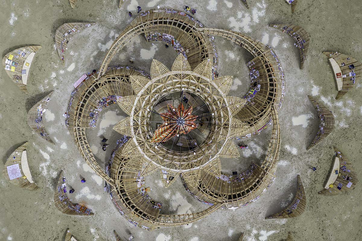 Top-down aerial of the 2026 Burning Man temple surrounded by rain puddles and mud on the playa, by Niaz Uddin