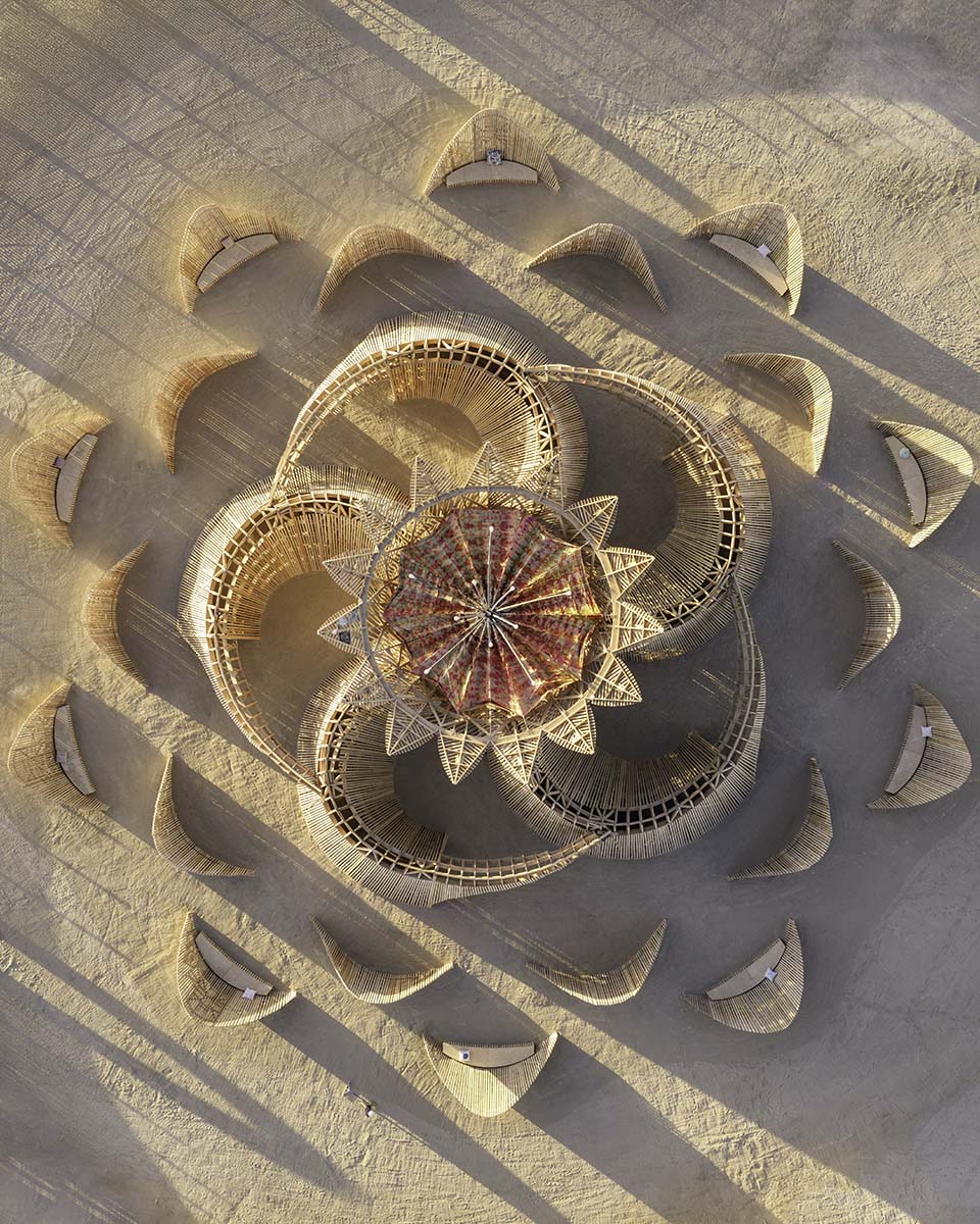Top-down aerial of the 2026 Burning Man temple casting long shadows across the playa at sunset, by Niaz Uddin