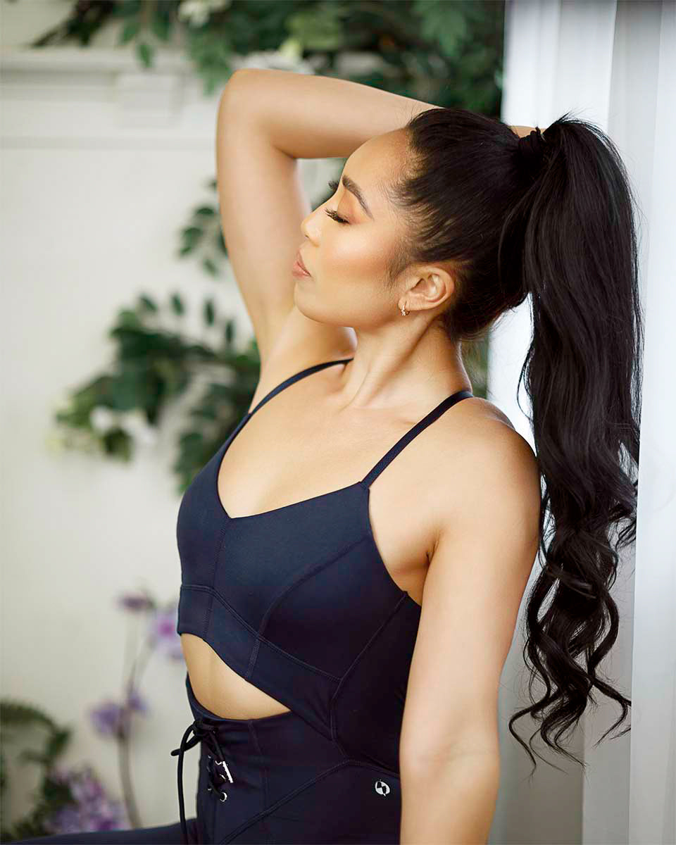 Profile of Cassey Ho in a navy POPFLEX lace-up set showing the side cutout and back detail, by Niaz Uddin