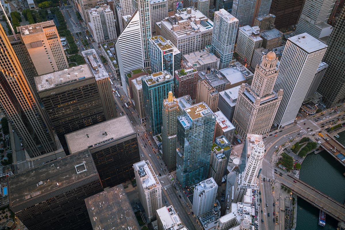 Aerial of the Chicago Loop at dusk with the Chicago River and its bridges in warm low light, by Niaz Uddin
