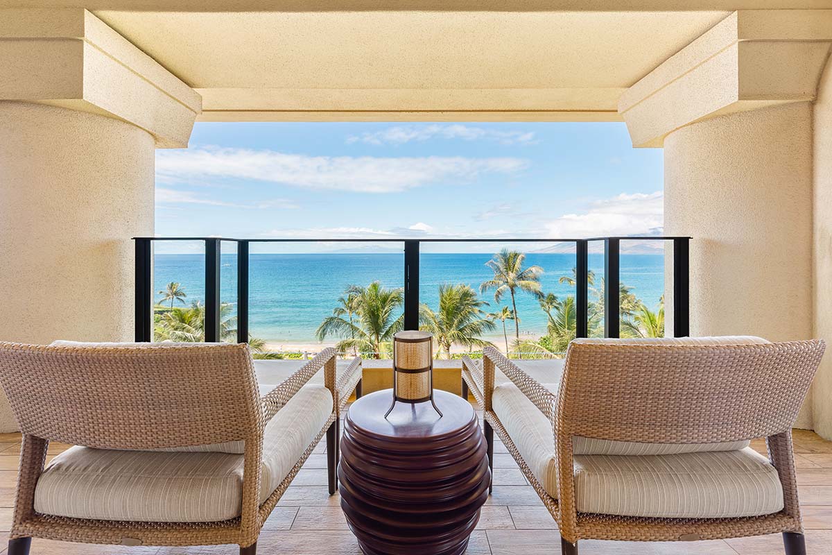 Private lanai with two wicker chairs framing an ocean and palm view at Four Seasons Resort Maui, by Niaz Uddin