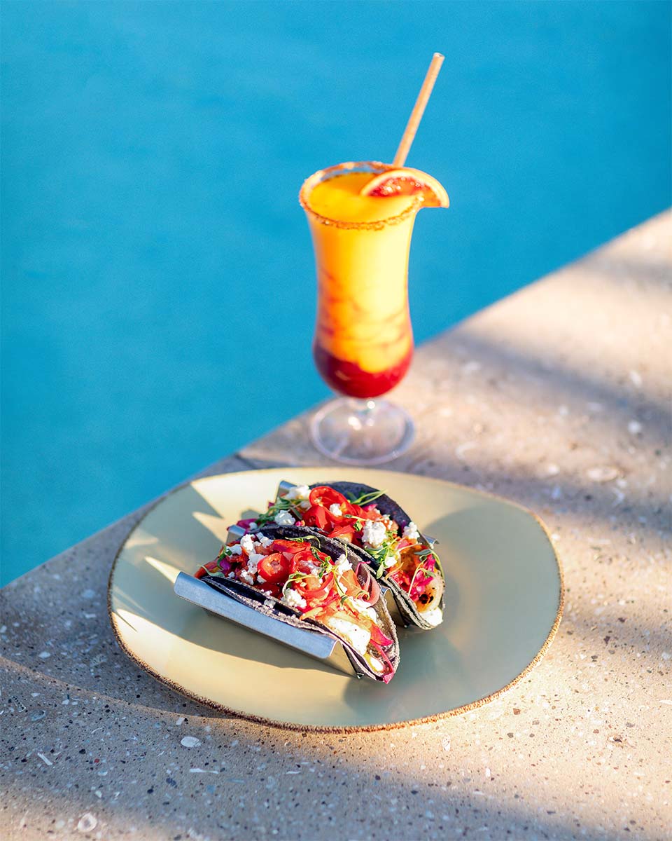 Blue-corn tacos and a frozen margarita on the pool ledge with turquoise water behind, Four Seasons Resort Maui, by Niaz Uddin