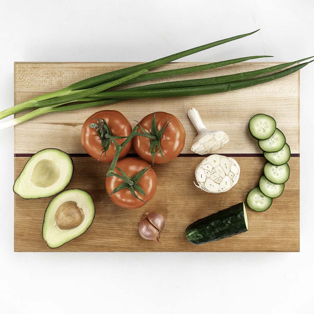 Avocado, vine tomatoes, cucumber, scallions, and garlic on a Hawker Woodcraft maple cutting board, by Niaz Uddin