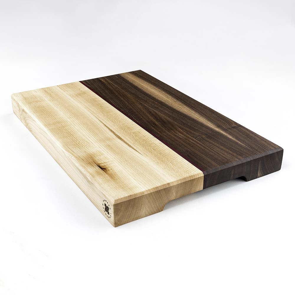 Angled product shot of a Hawker Woodcraft maple and walnut cutting board with a purpleheart accent stripe, by Niaz Uddin