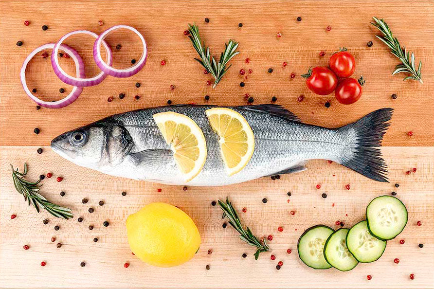 Whole sea bass with lemon, red onion, and cucumber on a Hawker Woodcraft maple serving board, by Niaz Uddin