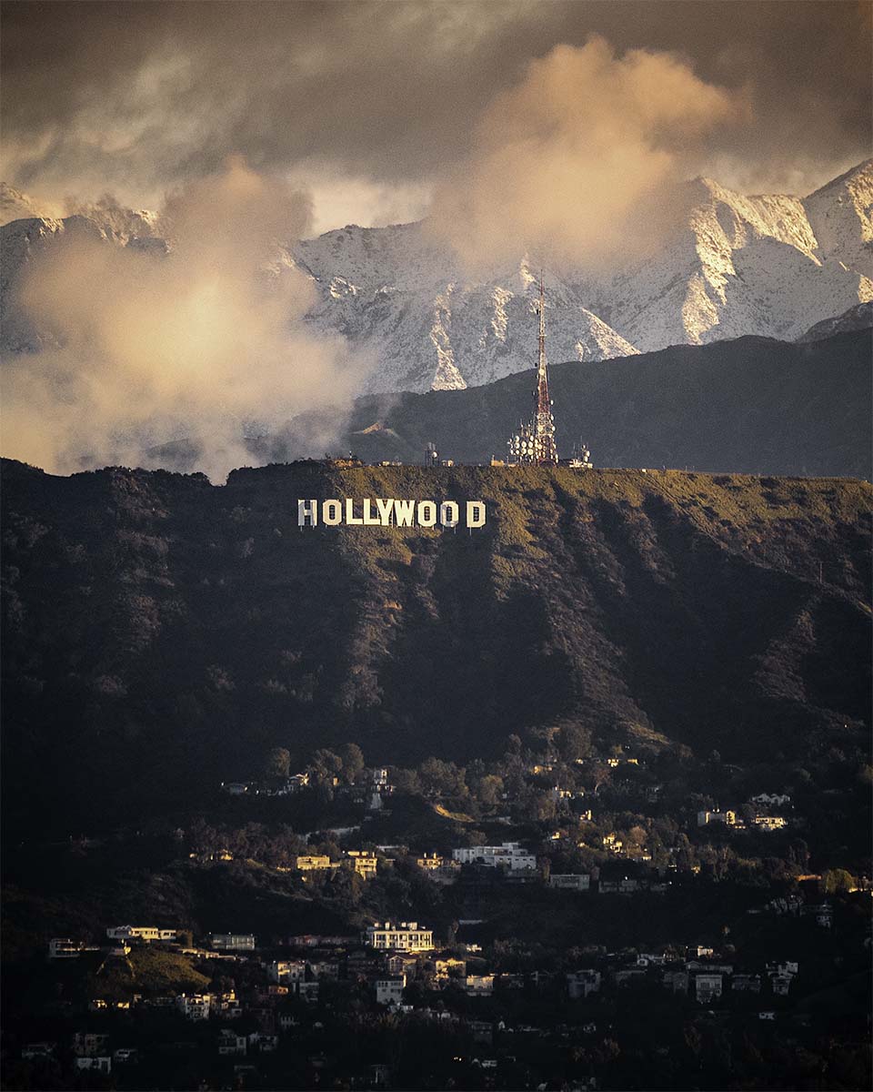 The Hollywood Sign with snow-capped mountains behind it in Los Angeles