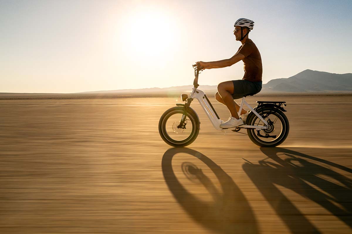 Backlit side profile of a rider on a white Kingbull Verve e-bike at sunset in the Mojave, by Niaz Uddin