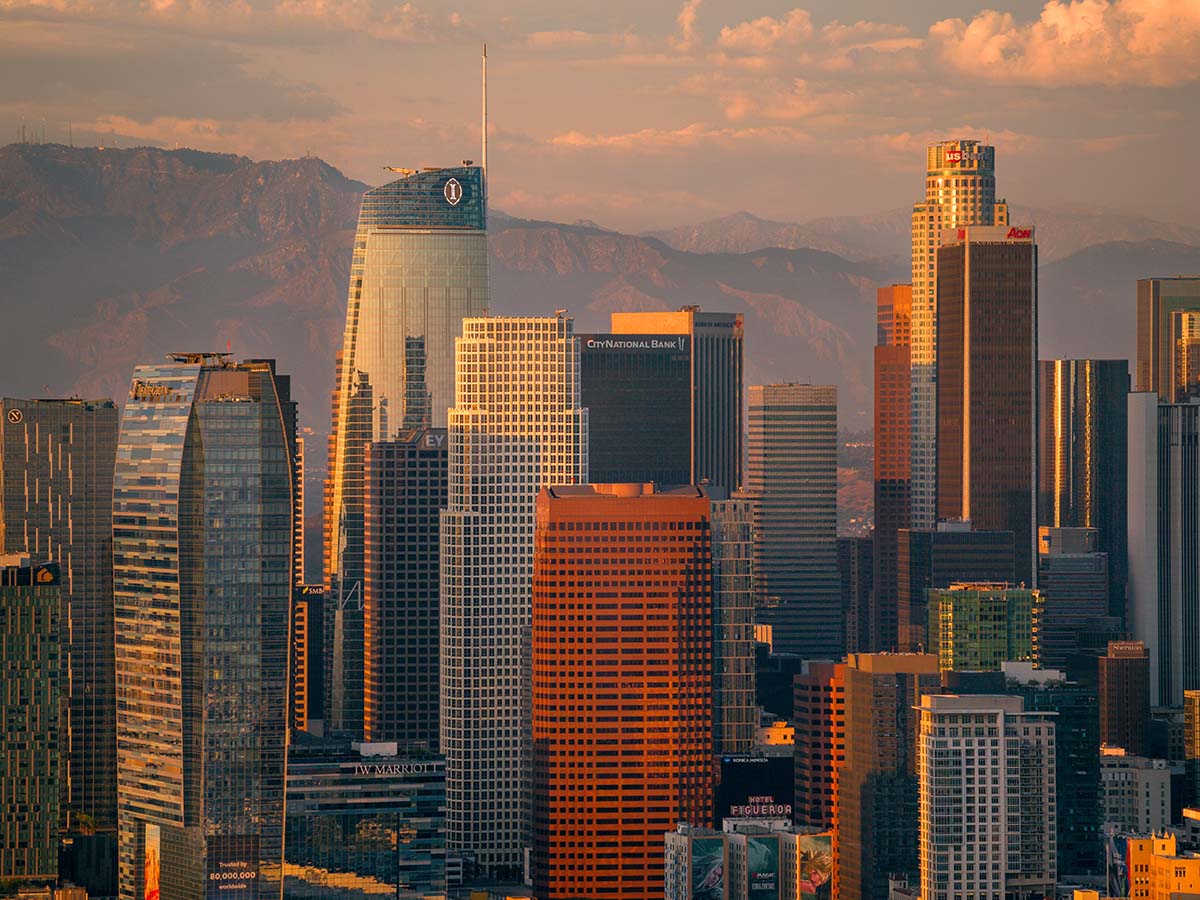 Blue hour aerial of downtown Los Angeles with lit towers and freeway light trails sweeping through the city, by Niaz Uddin
