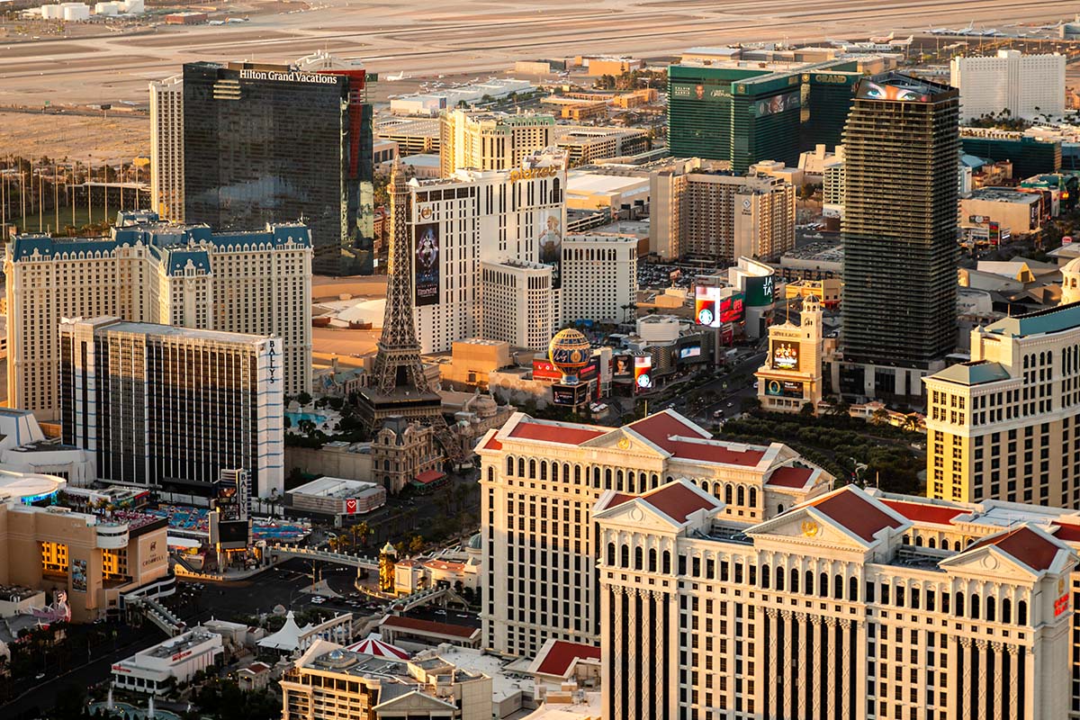 Golden-hour aerial of the Las Vegas Strip with the Paris Las Vegas Eiffel Tower, Bally's, Planet Hollywood, and Caesars Palace, by Niaz Uddin