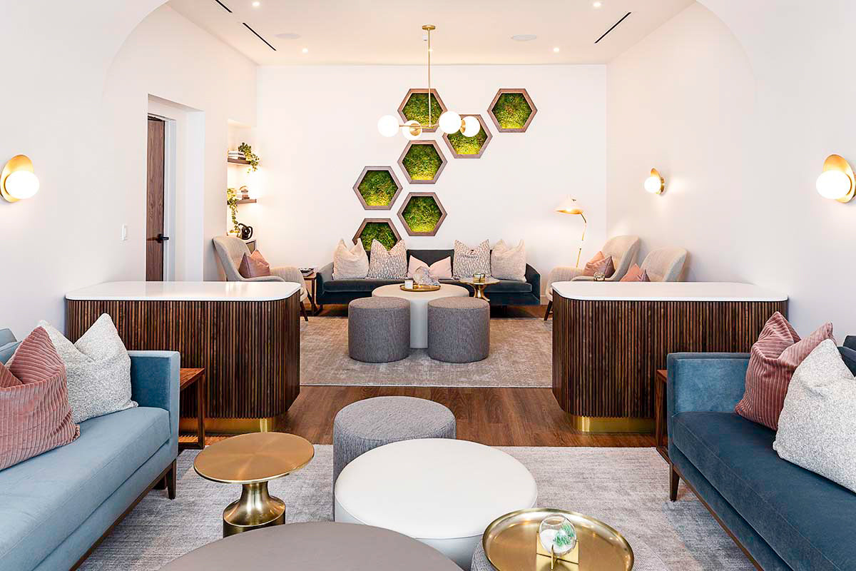 milk + honey relaxation lounge with a hexagonal moss wall, blue velvet sofas, and brass globe chandelier, by Niaz Uddin