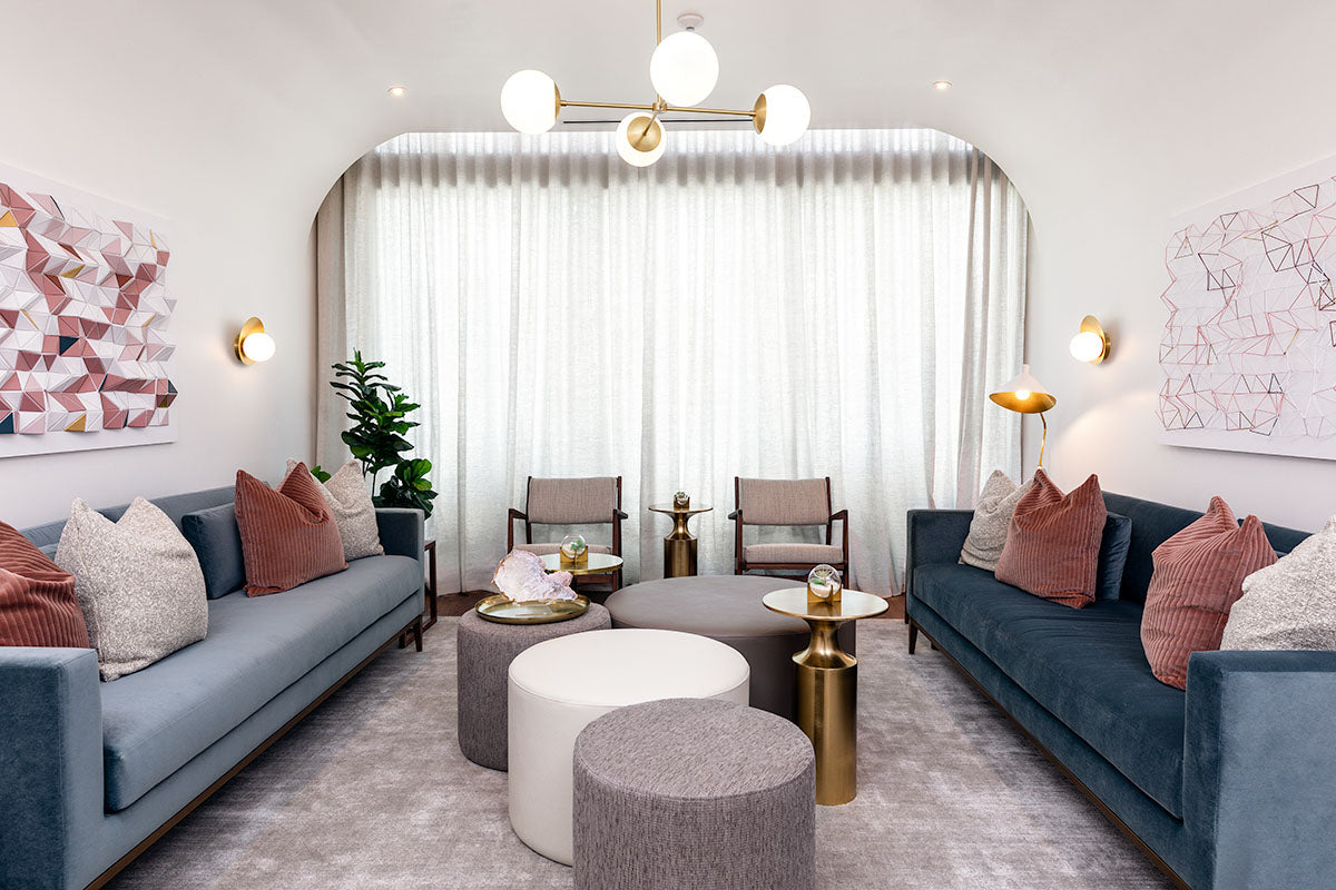 milk + honey relaxation lounge with sheer-curtained arch, blue and dusty-rose sofas, and geometric wall art, by Niaz Uddin