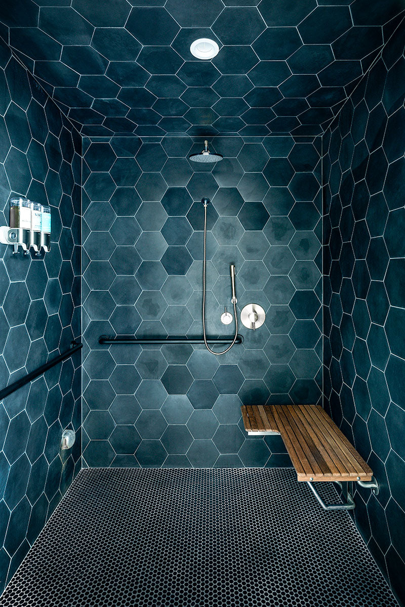 milk + honey steam shower clad in deep teal hexagon tile with a teak bench and penny-tile floor, by Niaz Uddin