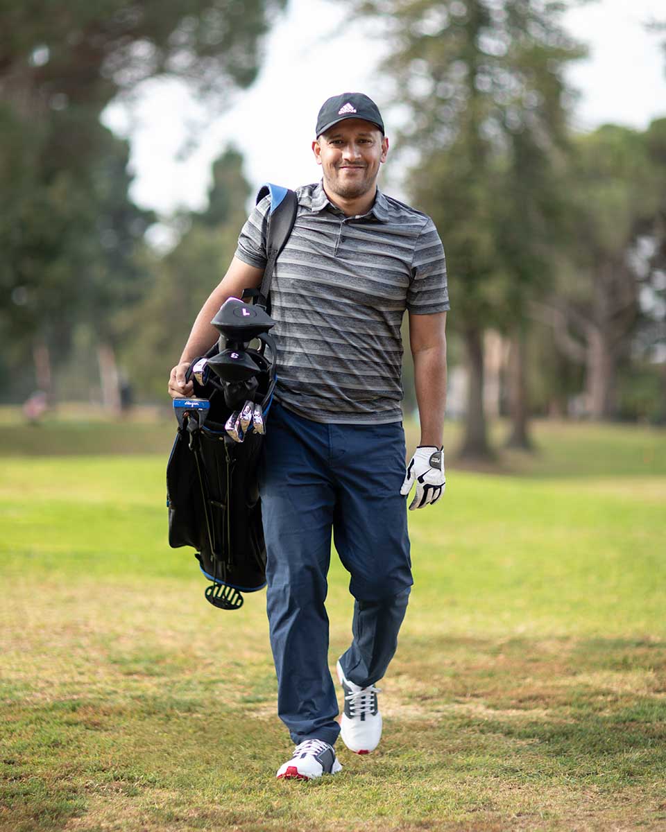 Niaz Uddin walking a golf course in Los Angeles carrying his clubs