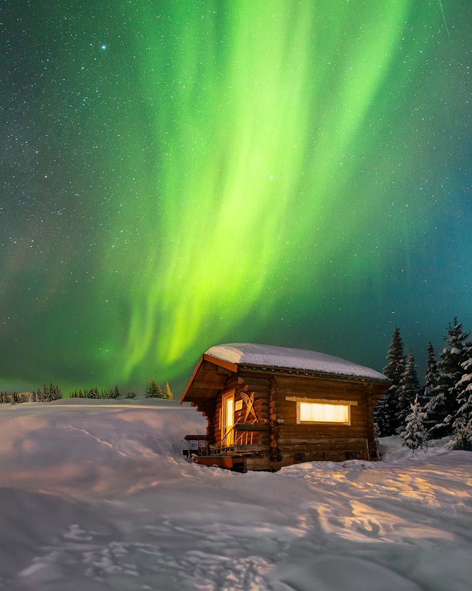 Northern lights over a snow-covered cabin in Alaska