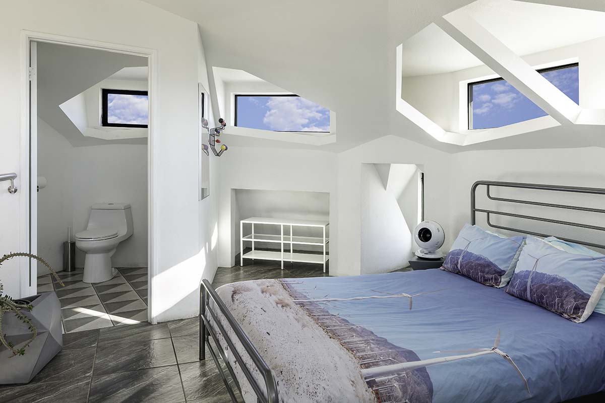White bedroom with angled sky-facing windows in the Palm Springs dome house, by Niaz Uddin