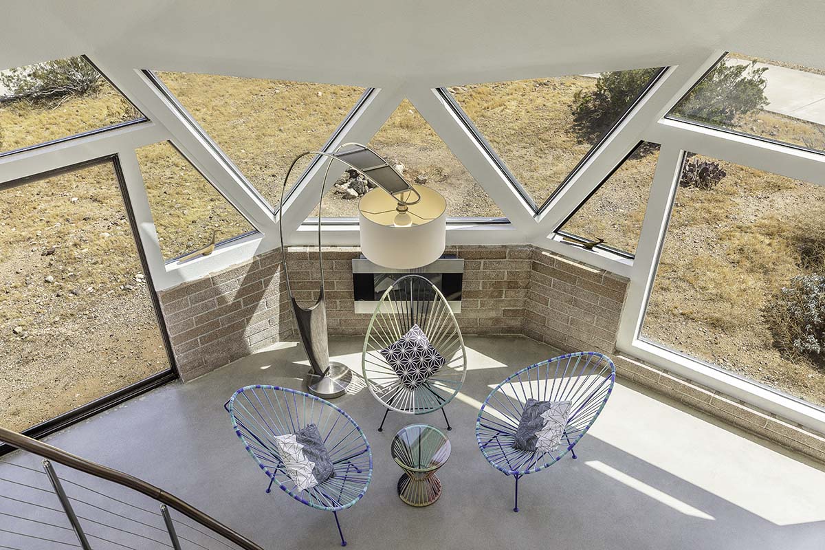 Looking down into a dome sitting nook with triangular windows and Acapulco chairs in the Palm Springs dome house, by Niaz Uddin
