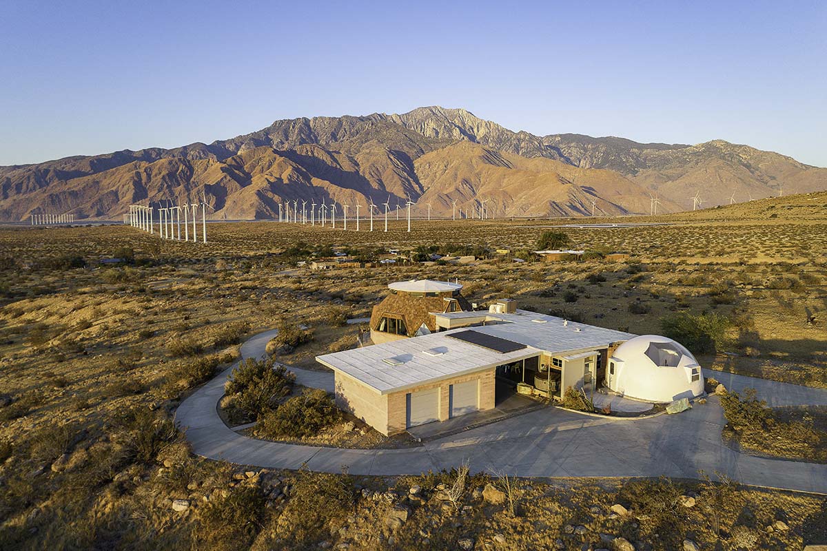 Aerial view of the geodesic dome house compound in the desert with wind turbines and the San Jacinto mountains behind, near Palm Springs, by Niaz Uddin